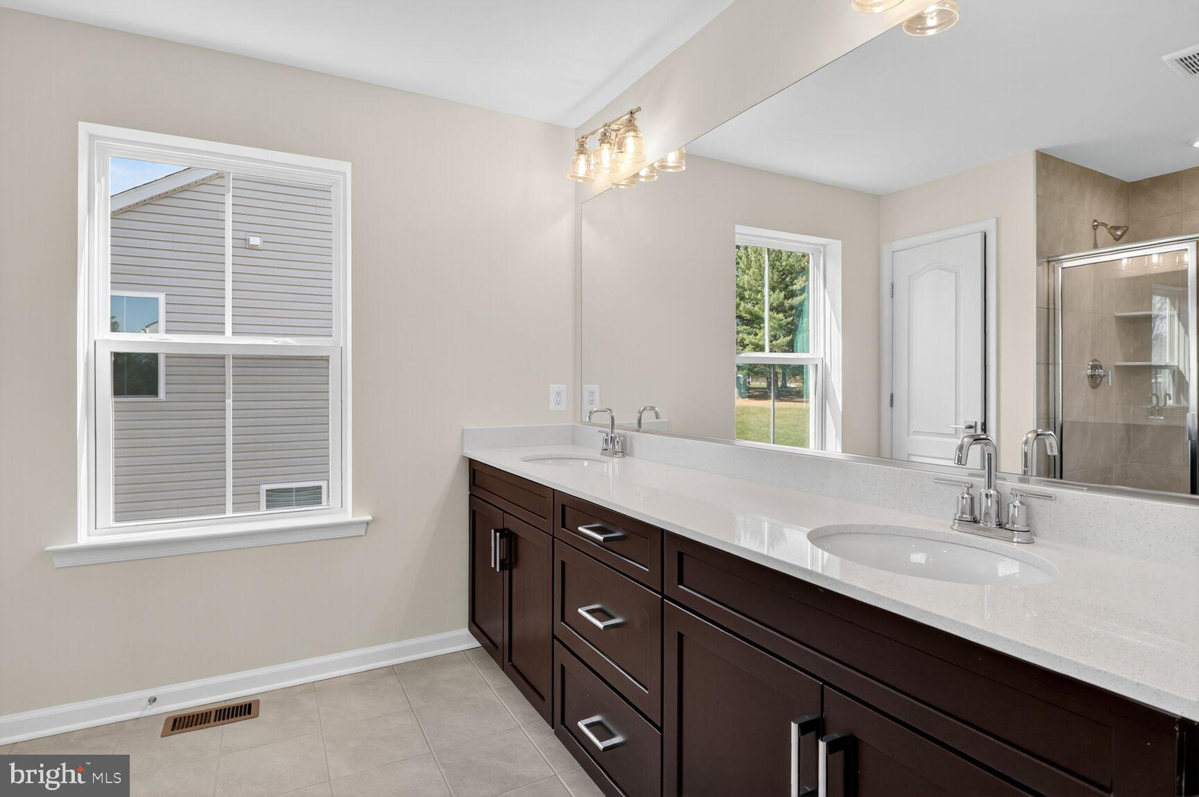 4016 Millner Road Nottingham, MD 21236 - Photo 14 of 15 a bathroom with a double vanity sink a large mirror and a window