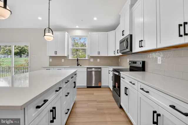 a kitchen with granite countertop white cabinets and white appliances
