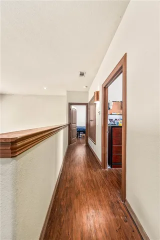 a view of a hallway with wooden floor and staircase