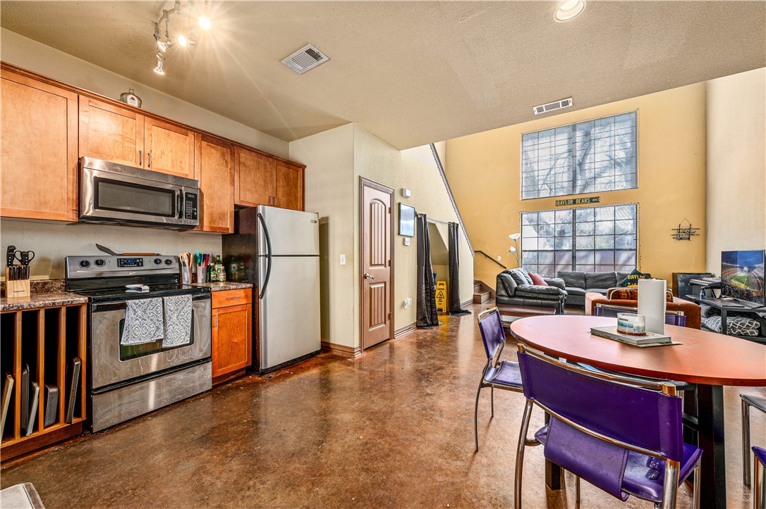 2410 2nd Street South Waco, TX 76706 - Photo 6 of 36 a kitchen with refrigerator cabinets dining table and chairs