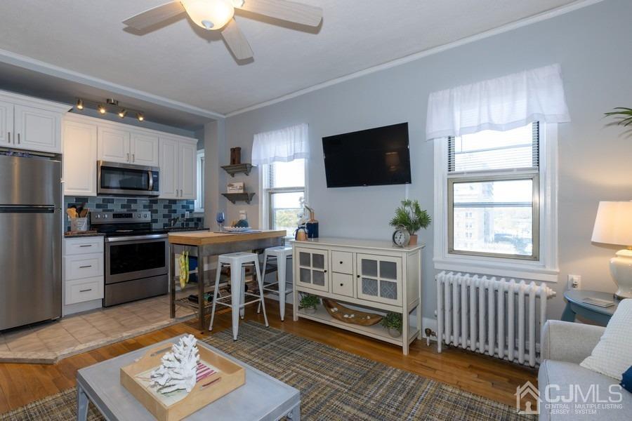 400 Deal Lake Drive, Unit 4G Asbury Park, NJ 07712 - Photo 12 of 20 a living room with stainless steel appliances furniture a flat screen tv and a window