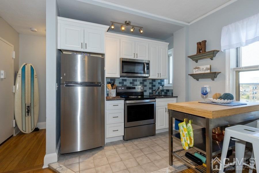 400 Deal Lake Drive, Unit 4G Asbury Park, NJ 07712 - Photo 14 of 20 a kitchen with stainless steel appliances a refrigerator a stove a sink and a refrigerator