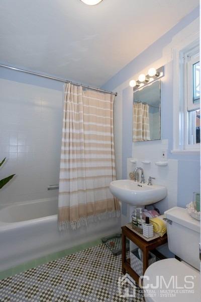 400 Deal Lake Drive, Unit 4G Asbury Park, NJ 07712 - Photo 16 of 20 a bathroom with a sink toilet and shower