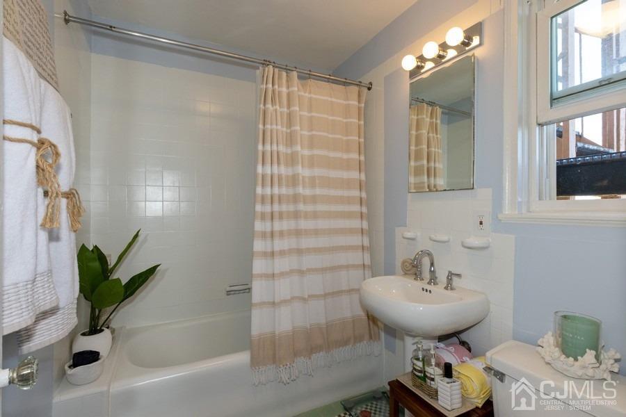 400 Deal Lake Drive, Unit 4G Asbury Park, NJ 07712 - Photo 17 of 20 a bathroom with a sink toilet and shower