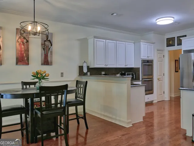 a kitchen with a table chairs refrigerator and cabinets