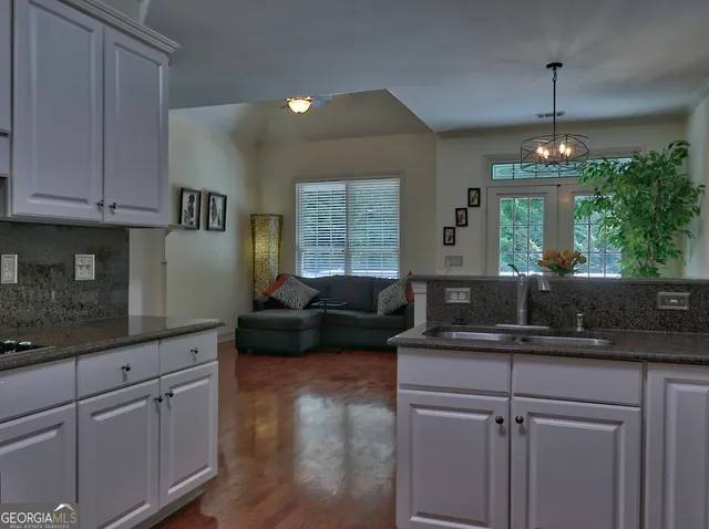 a kitchen with kitchen island granite countertop a sink cabinets and window