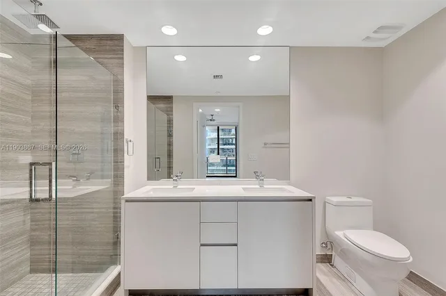 a bathroom with a sink toilet vanity and shower