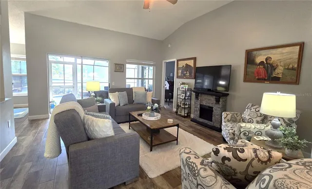 a living room with furniture a flat screen tv and a large window