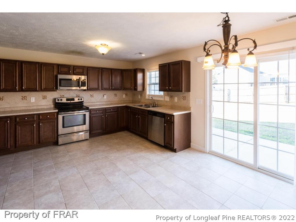 47 Rockingham Street Spring Lake, NC 28390 - Photo 6 of 27 a kitchen with kitchen island granite countertop a sink and stainless steel appliances