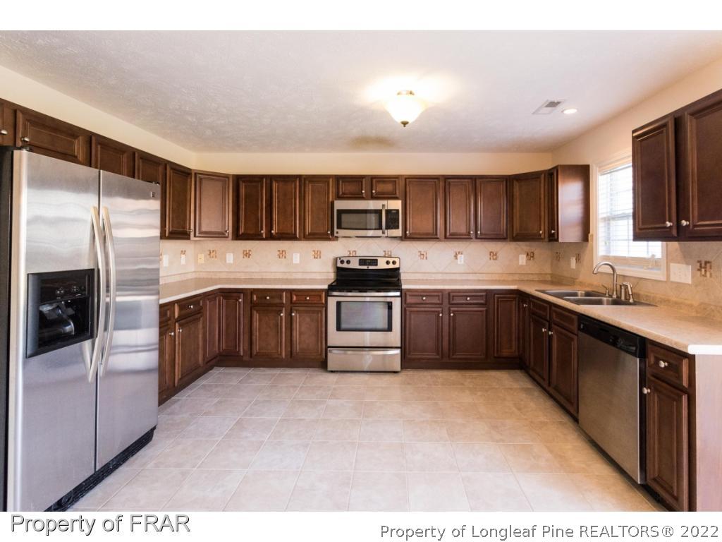 47 Rockingham Street Spring Lake, NC 28390 - Photo 7 of 27 a kitchen with stainless steel appliances granite countertop a refrigerator and a stove top oven