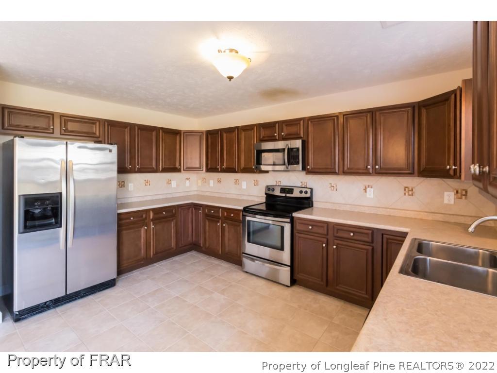 47 Rockingham Street Spring Lake, NC 28390 - Photo 8 of 27 a kitchen with stainless steel appliances granite countertop a refrigerator sink and cabinets