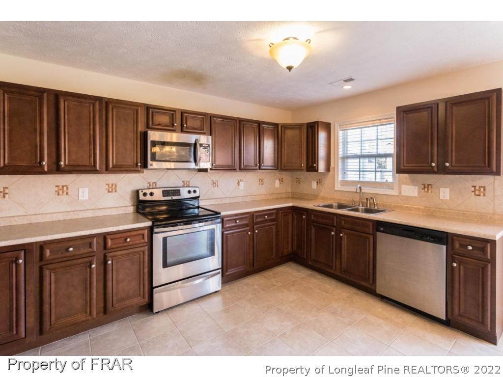 47 Rockingham Street Spring Lake, NC 28390 - Photo 9 of 27 a kitchen with stainless steel appliances granite countertop a stove sink and cabinets