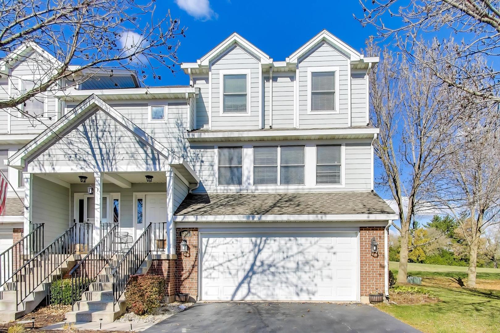 a view of a white house with large windows and a table and chair
