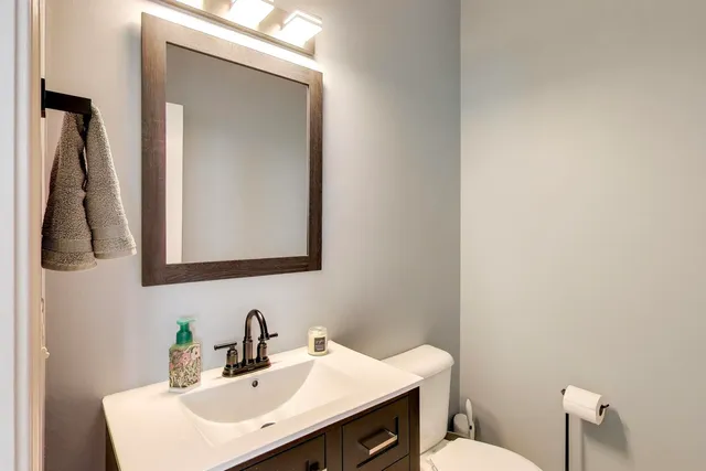 a bathroom with a toilet sink and mirror