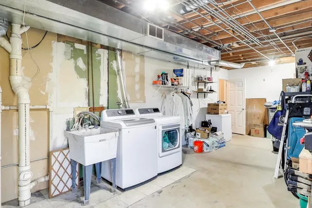 a utility room with dryer washer and a view of living room