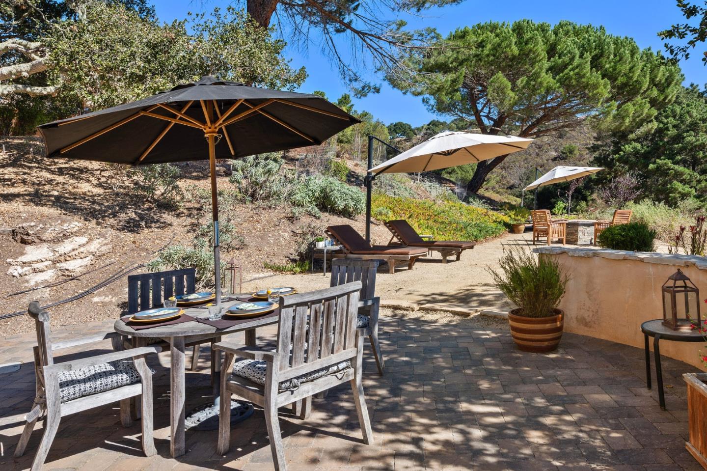 175 Chaparral Road Carmel Valley, CA 93924 - Photo 50 of 66 a view of a patio with a table and chairs under an umbrella