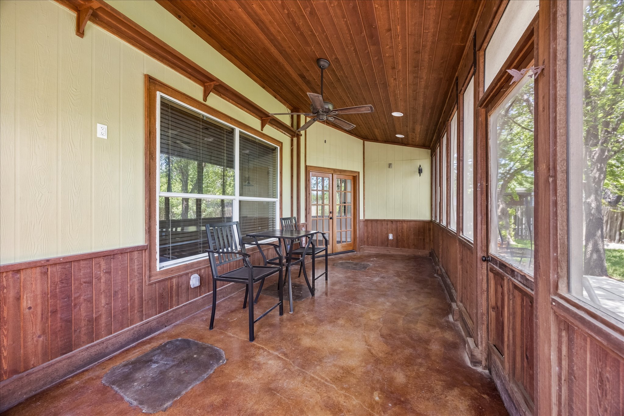 338 Spring Branch Loop Kyle, TX 78640 - Photo 28 of 36 A screened-in porch with wooden ceilings offers a serene spot for relaxation and enjoyment of the outdoors.