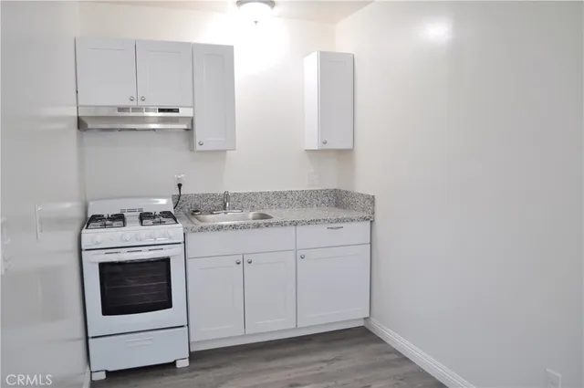 a kitchen with granite countertop white cabinets and white appliances