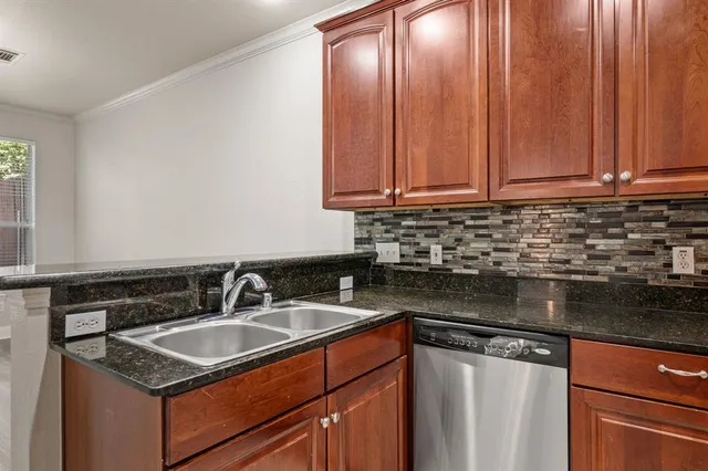 a kitchen with granite countertop a sink a stove and cabinets