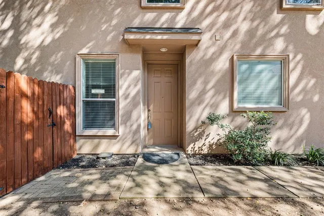 a view of a house with a door and wooden bench