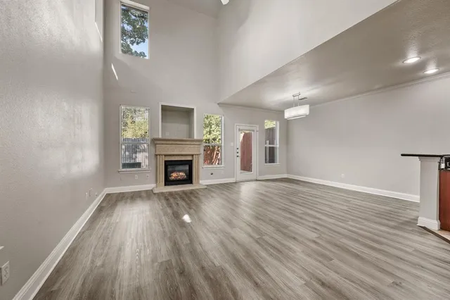 an empty room with wooden floor and fireplace