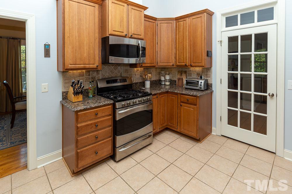 5021 Martin Farm Road Raleigh, NC 27613 - Photo 7 of 30 a kitchen with stainless steel appliances a stove a microwave and a sink