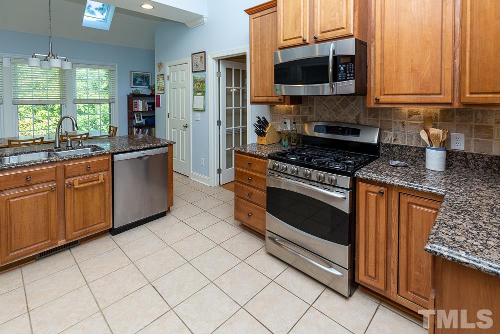 5021 Martin Farm Road Raleigh, NC 27613 - Photo 9 of 30 a kitchen with stainless steel appliances granite countertop a stove a sink and a microwave