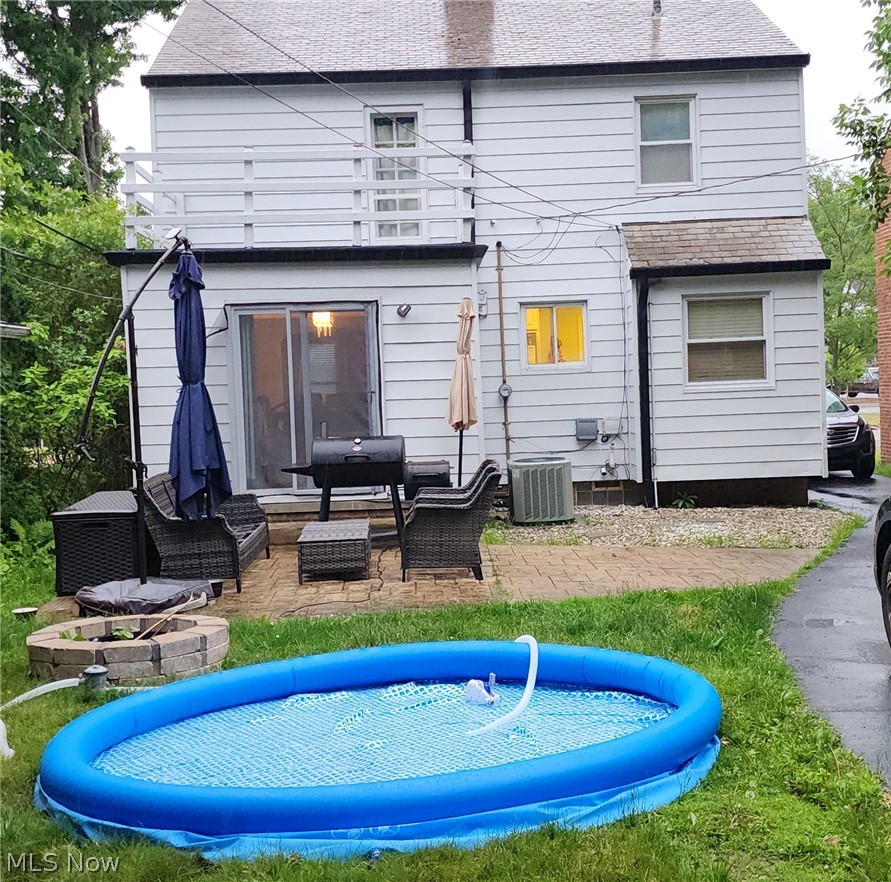 2164 Fenwick Road Cleveland, OH 44118 - Photo 3 of 4 Back of property featuring a patio, an outdoor hangout area, a trampoline, and central air condition unit