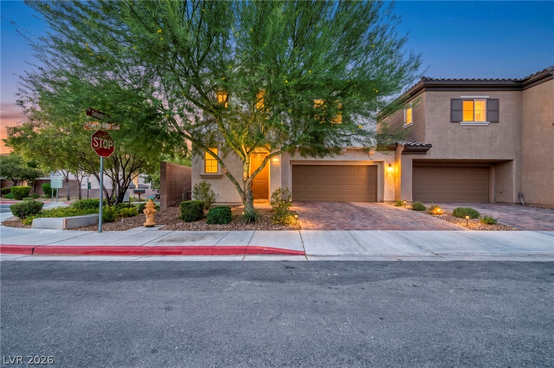 5014 Fiery Sky Ridge Street Las Vegas, NV 89148 - Photo 1 of 21 A well-maintained stucco exterior home with warm outdoor lighting.