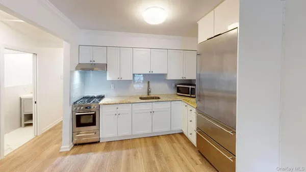 a kitchen with stainless steel appliances granite countertop a stove and white cabinets