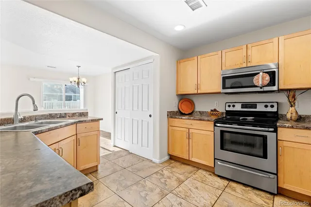 a kitchen with stainless steel appliances granite countertop a stove a sink and a microwave