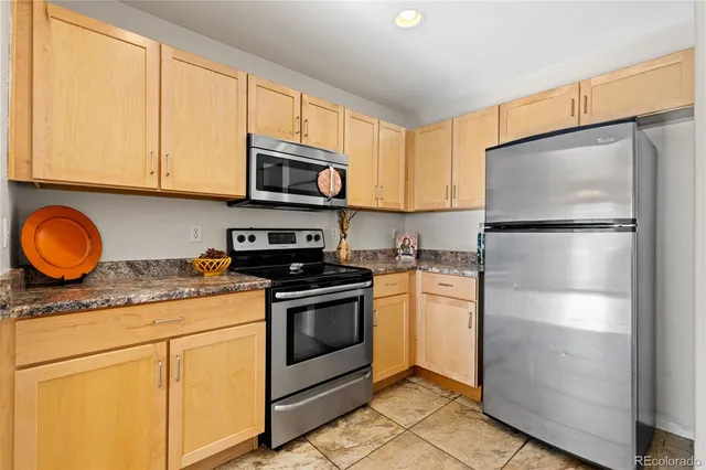 a kitchen with granite countertop stainless steel appliances a stove a microwave a sink and cabinets