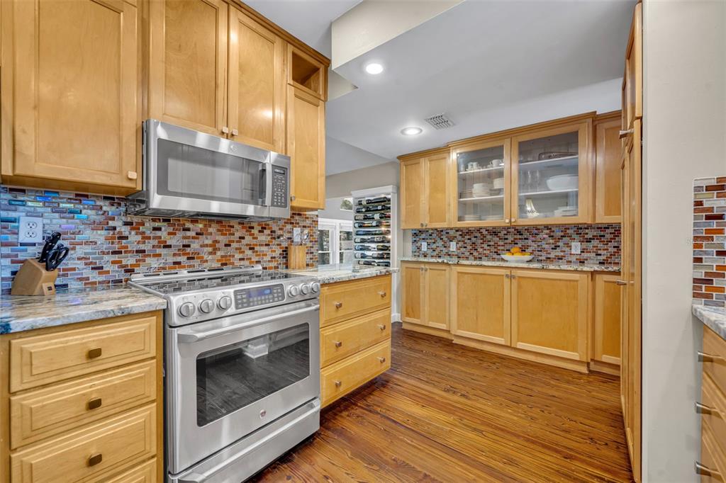 1960 Winter Park Road Winter Park, FL 32789 - Photo 20 of 46 a kitchen with stainless steel appliances white cabinets and a wooden floor