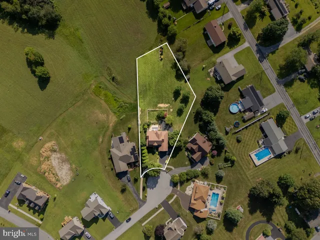 an aerial view of a house with a yard basket ball court and outdoor seating