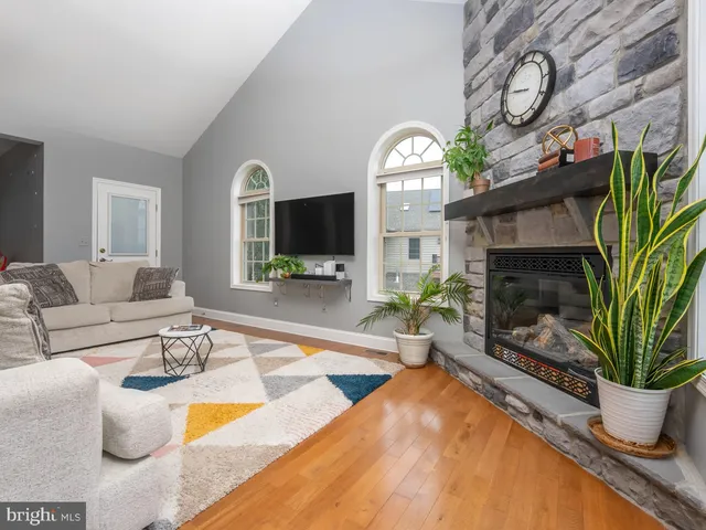 a bedroom with a bed a chair and potted plant on the dresser