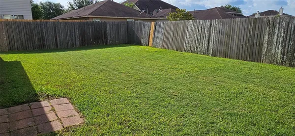 a view of backyard with wooden fence