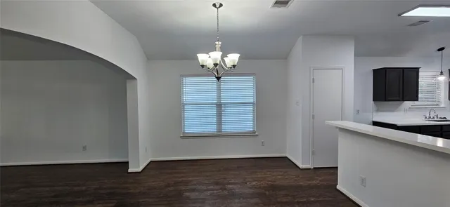 a view of wooden floor and a chandelier in a room