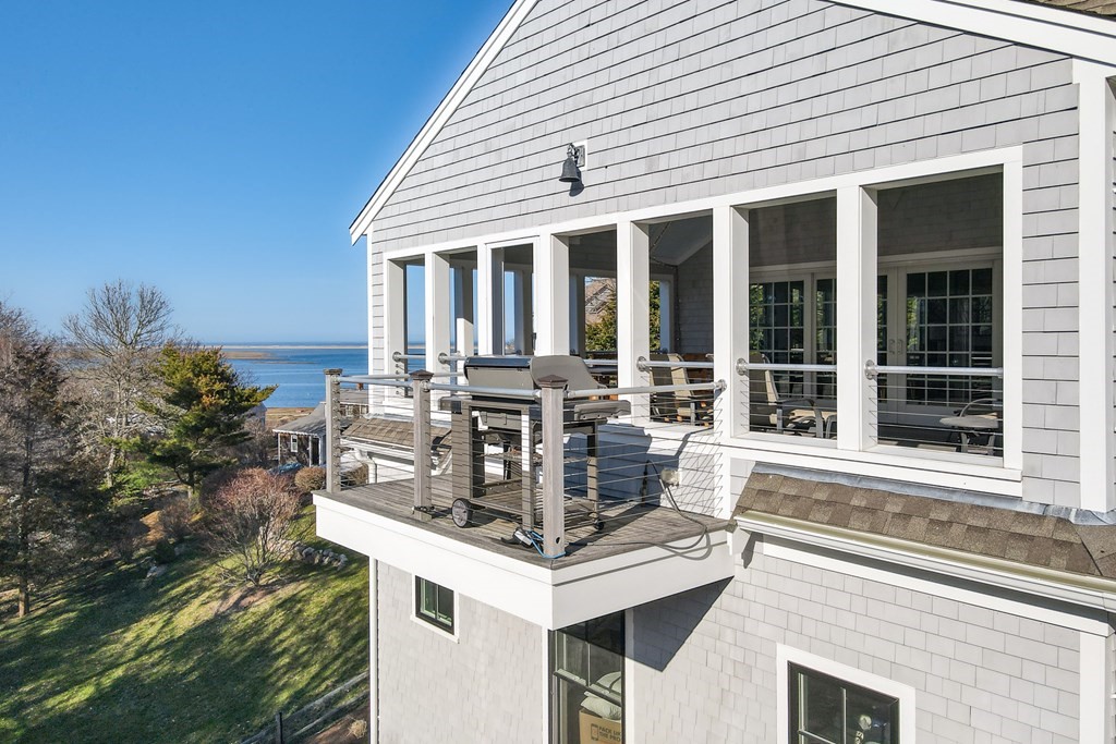 18 Snow Shore Road Orleans, MA 02653 - Photo 22 of 42 a view of a white house with large windows and couches