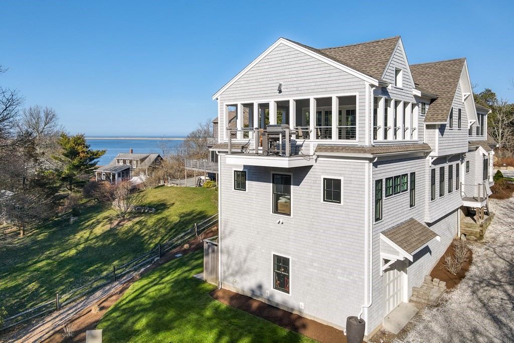 18 Snow Shore Road Orleans, MA 02653 - Photo 38 of 42 a view of a white house next to a yard with big trees