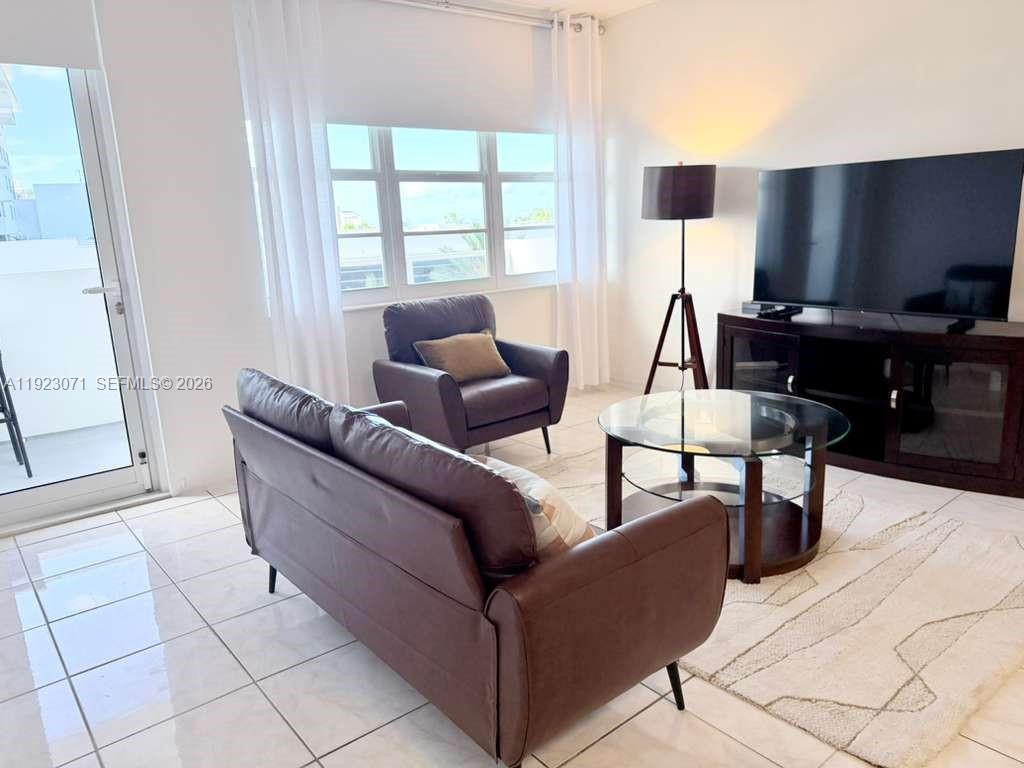 100 Lincoln Road, Unit 541 Miami Beach, FL 33139 - Photo 5 of 17 a living room with couches and a flat screen tv with kitchen view