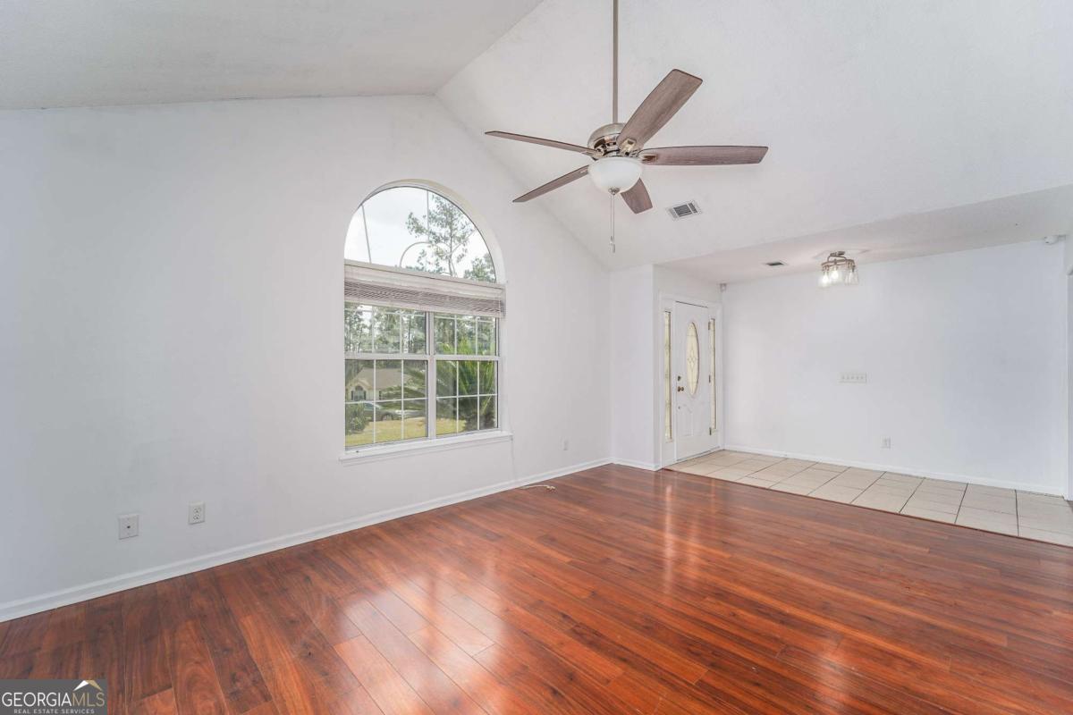 301 Ridge Lane Douglas, GA 31533 - Photo 8 of 26 wooden floor in an empty room with a window