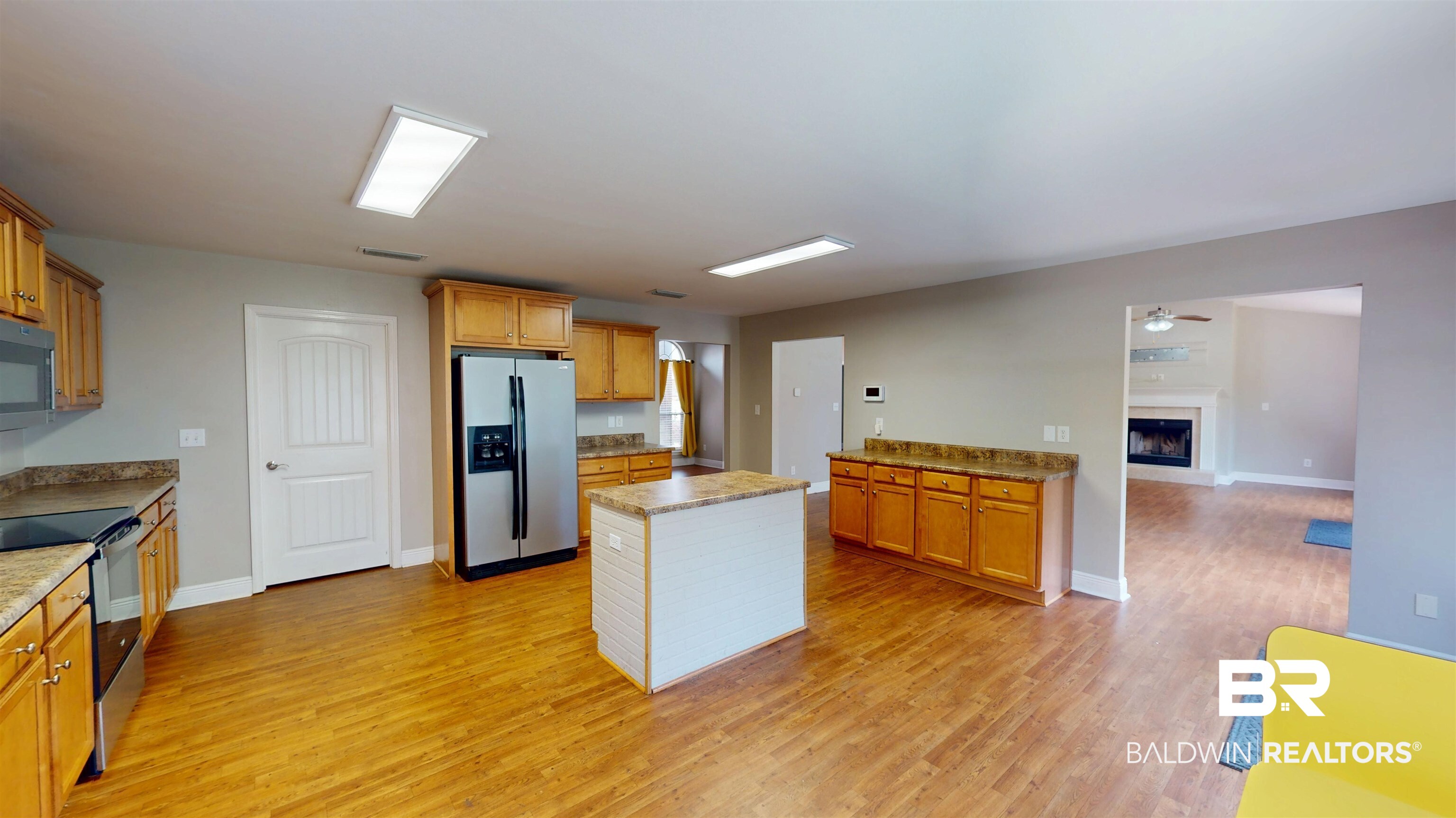10753 Rigby Drive Mobile, AL 36695 - Photo 11 of 33 Kitchen with a kitchen island, visible vents, light wood-style flooring, appliances with stainless steel finishes, and a fireplace