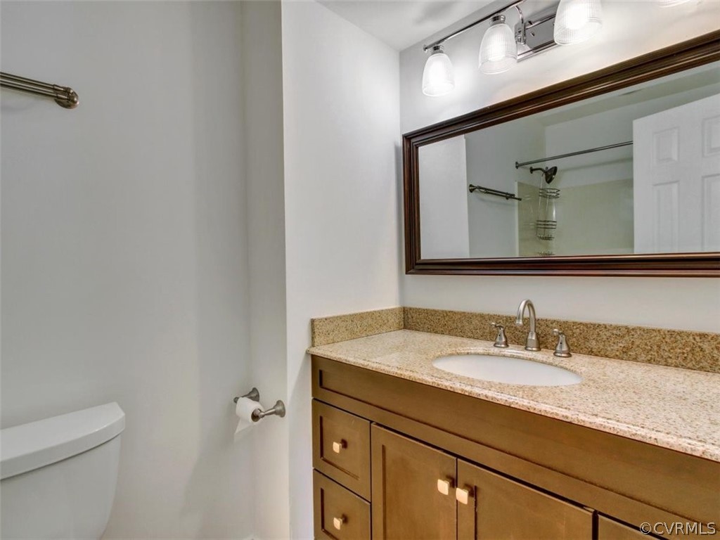 11130 Rufford Road Chester, VA 23831 - Photo 13 of 23 a bathroom with a granite countertop sink a toilet and a mirror