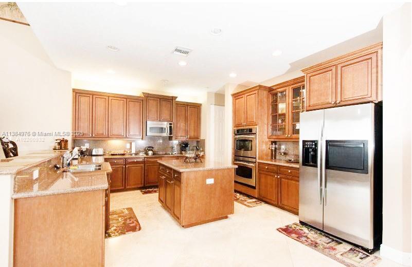 Miramar Miramar, FL 33029 - Photo 18 of 20 a kitchen with stainless steel appliances kitchen island granite countertop a refrigerator a stove and a sink with cabinets