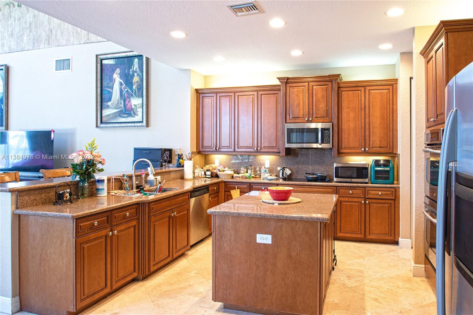 Miramar Miramar, FL 33029 - Photo 7 of 20 a kitchen with stainless steel appliances granite countertop wooden cabinets a sink a stove a refrigerator and blue cabinets