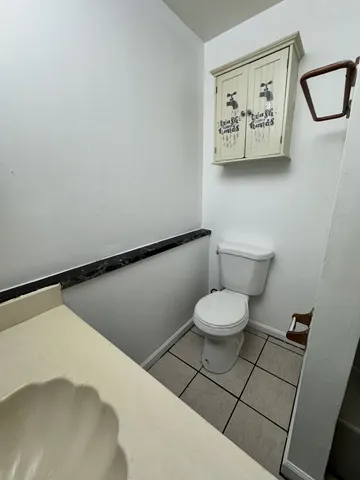 a bathroom with a toilet and a picture on the wall