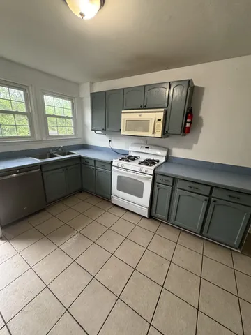 a kitchen with a sink a stove top oven and cabinetry