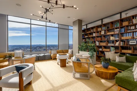 a very nice looking living room with a large window and a book shelf