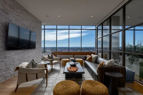 a living room with furniture a floor to ceiling window and a flat screen tv