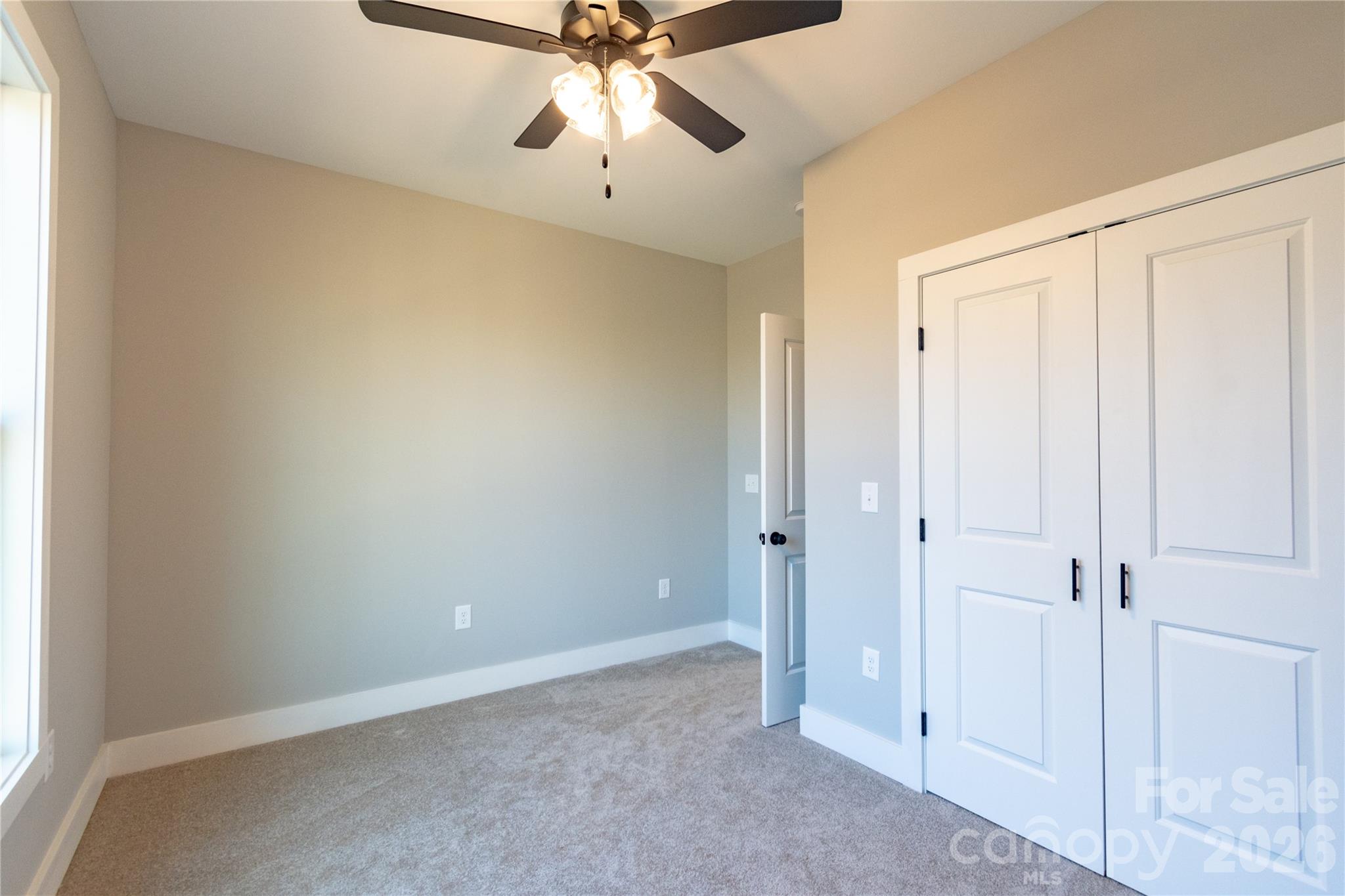 472 Oak Road Norwood, NC 28128 - Photo 13 of 27 an empty room with a ceiling fan and a window